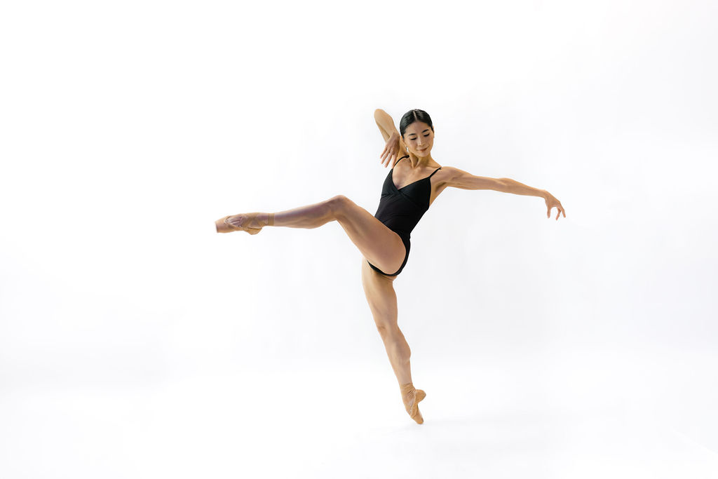 Ballet dancer in black leotard in dance pose