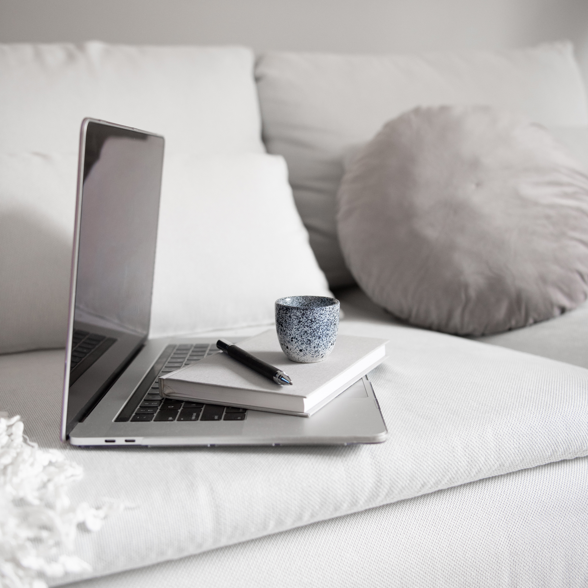 copywriting setup on couch with computer and mug