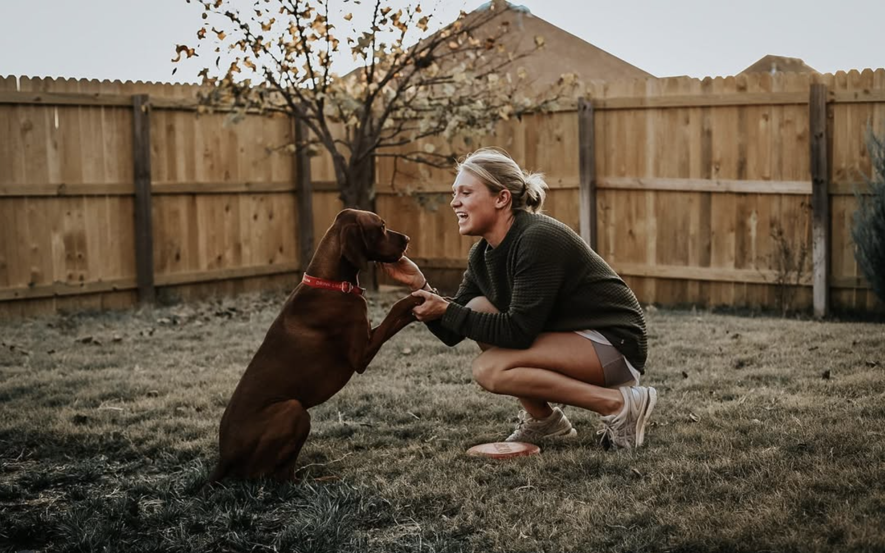 woman and dog outside in backyard